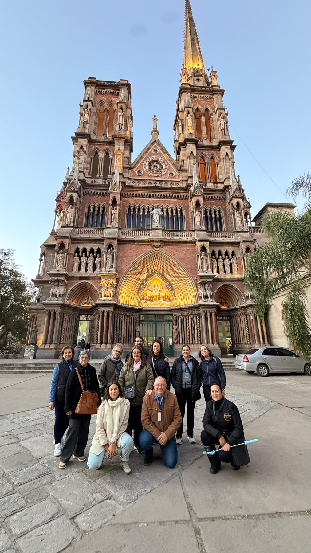 Grupo posando em frente à Catedral Metropolitana com céu azul ao fundo