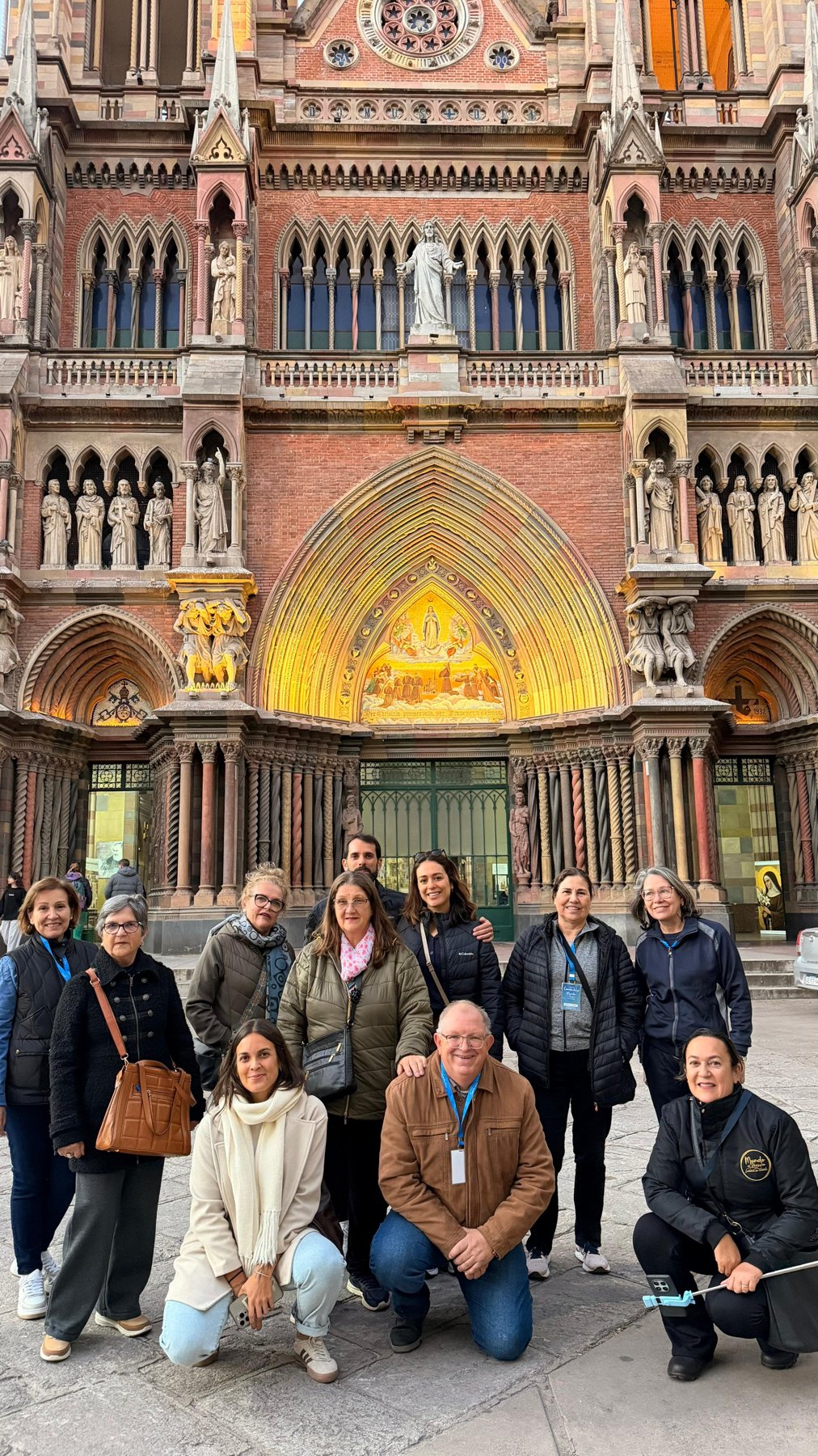 Grupo grande posando em frente à Catedral Metropolitana, sol direto, todos visivelmente felizes