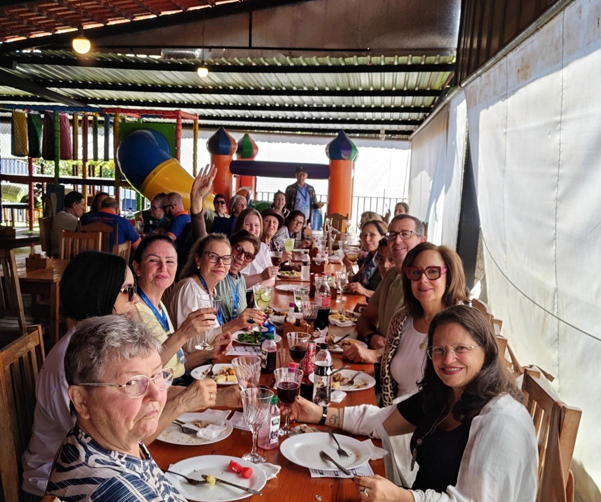 Refeição em mesa com grupo em ambiente interior bem iluminado