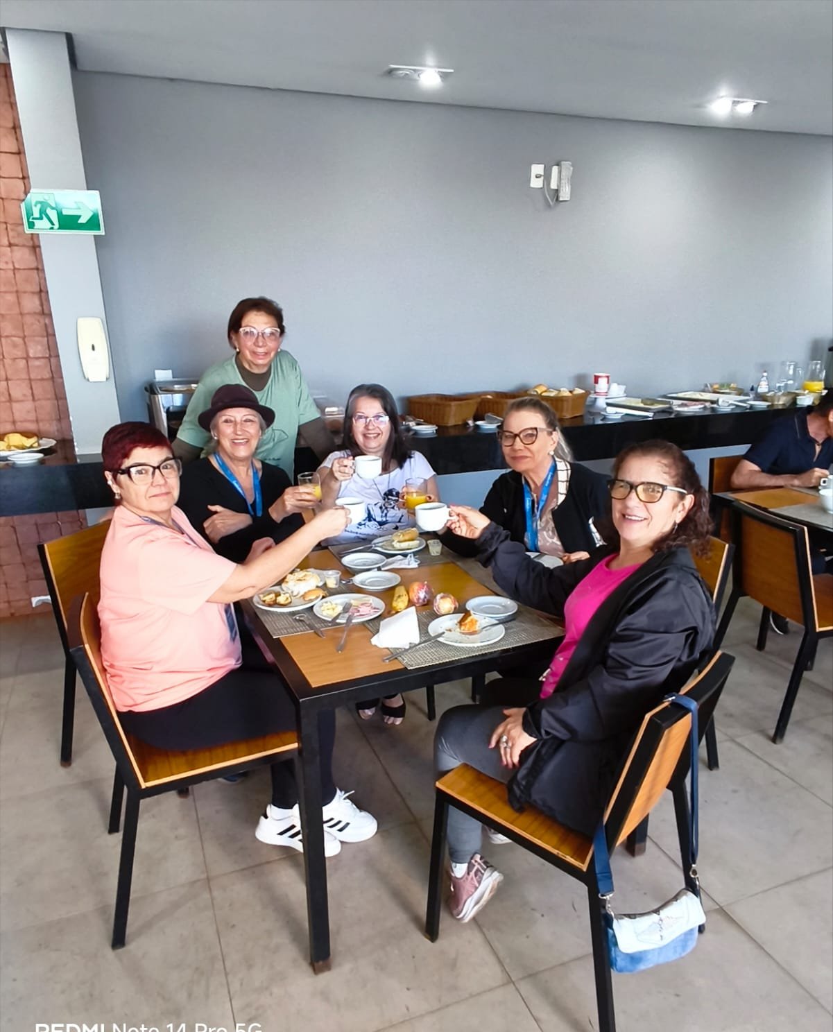 Refeição coletiva em mesa grande com pessoas sorridentes e ambiente aconchegante