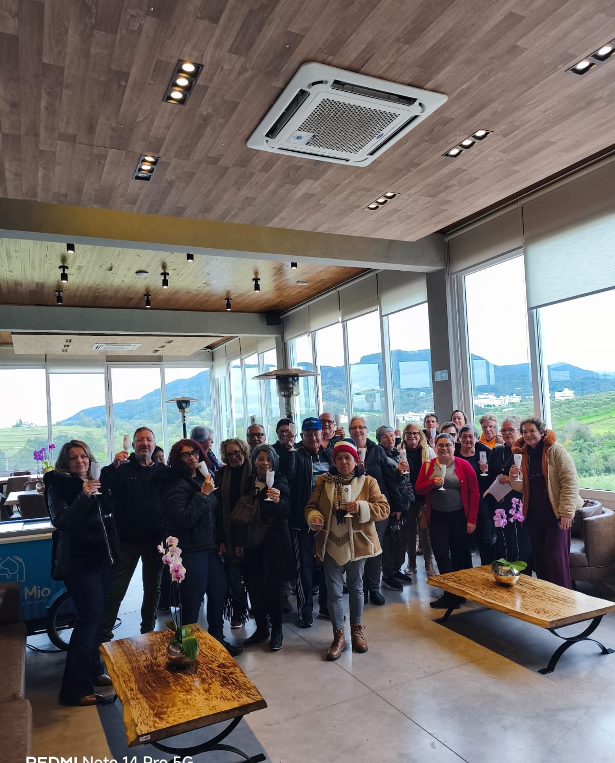 Grupo reunido em espaço coberto em refeição ou evento social