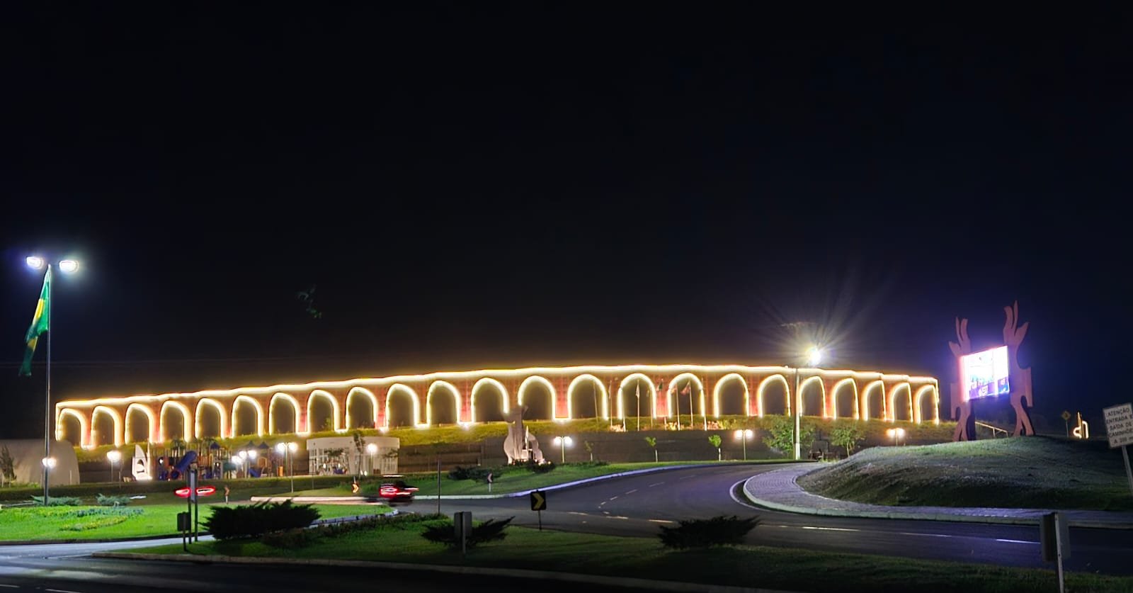 Aqueduto histórico iluminado à noite, ponto turístico destacado
