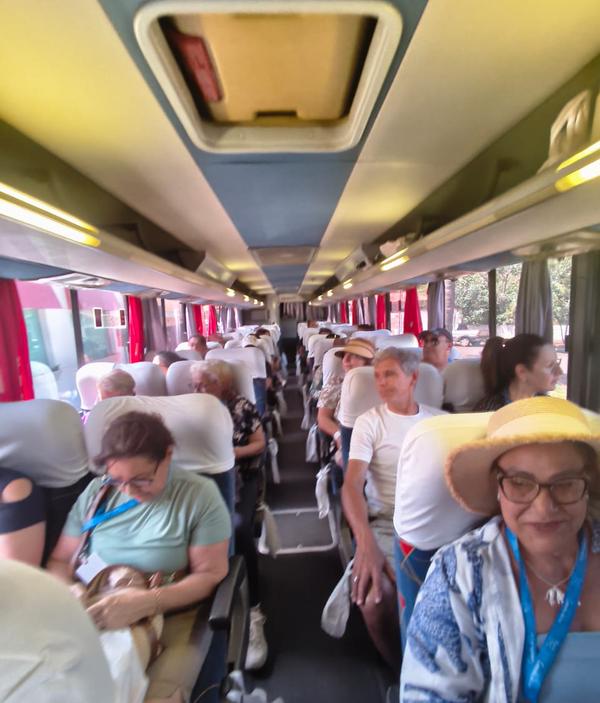 Passageiros sentados ao longo do corredor do onibus durante o trajeto