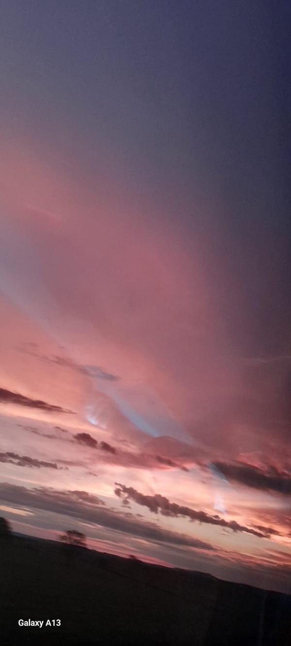 Ceu rosado ao entardecer com nuvens em camadas sobre o horizonte