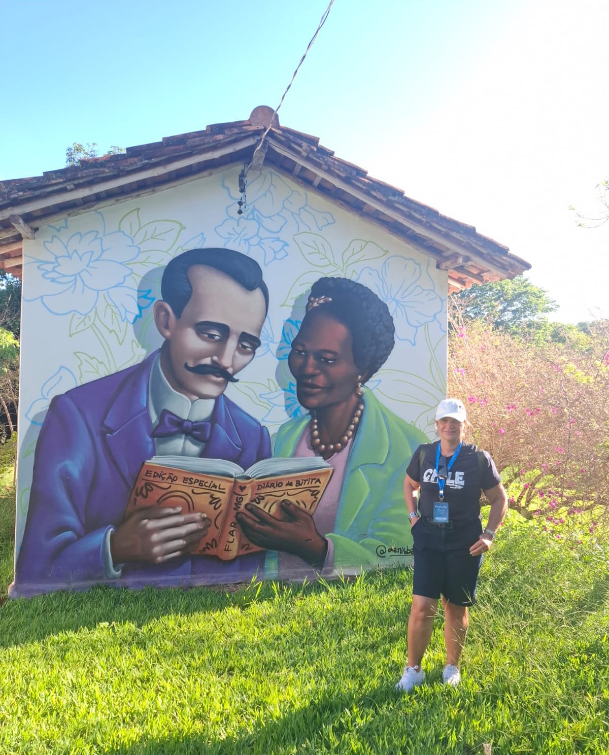 Pessoas em frente a construção com arte mural, ponto turístico, composição clara