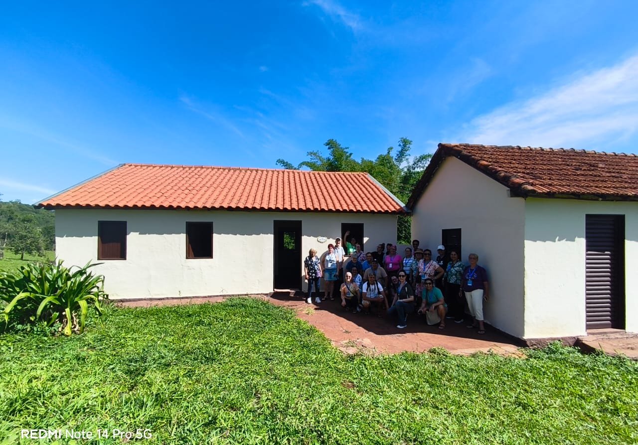 Grupo em frente a construção colonial, luz natural, momento de pausa