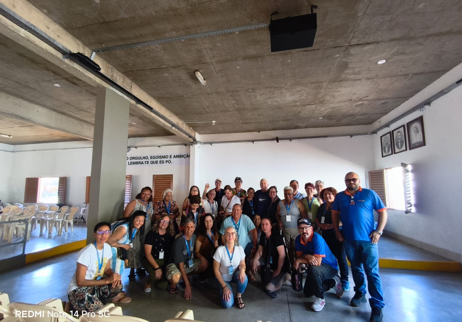 Grupo em evento interno, pessoas reunidas em espaço de apresentação, luz adequada