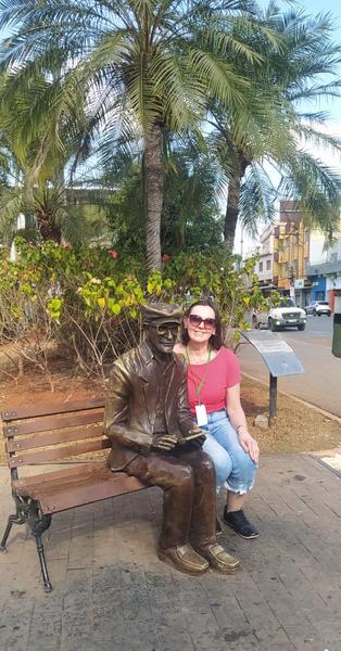 Estátua de bronze num banco de praça, numa parada da caravana de julho de 2024.