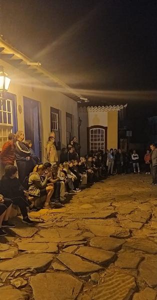 Apresentação à noite numa rua de pedra, na caravana a Minas Gerais de julho de 2024.