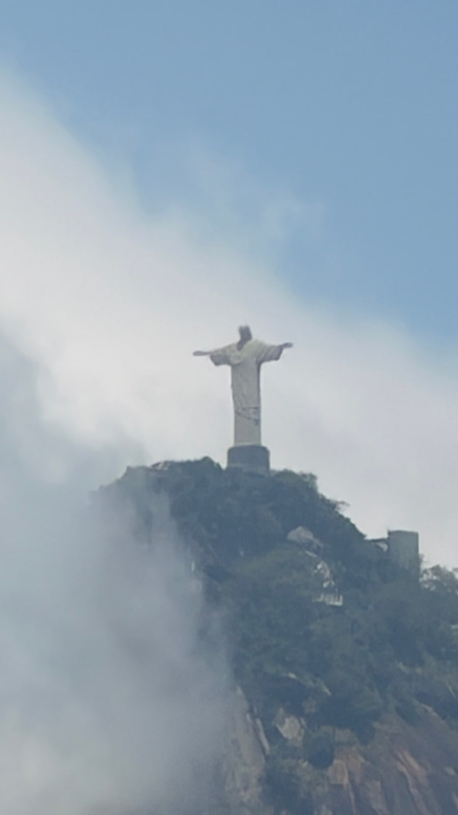 Cristo Redentor distante entre as nuvens