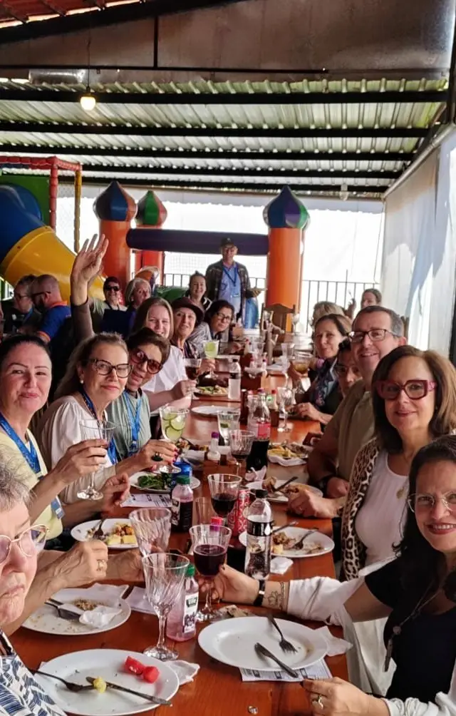 Refeição em mesa com grupo em ambiente interior bem iluminado