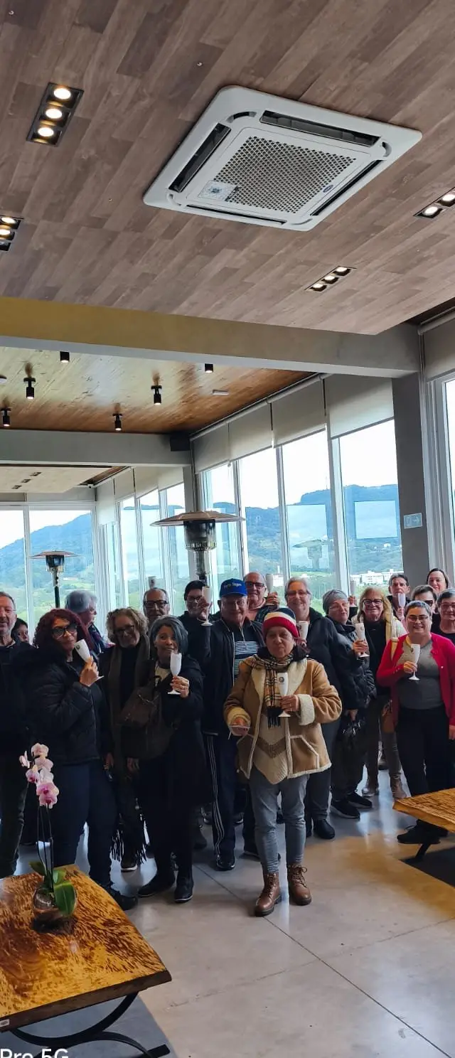Grupo reunido em espaço coberto em refeição ou evento social