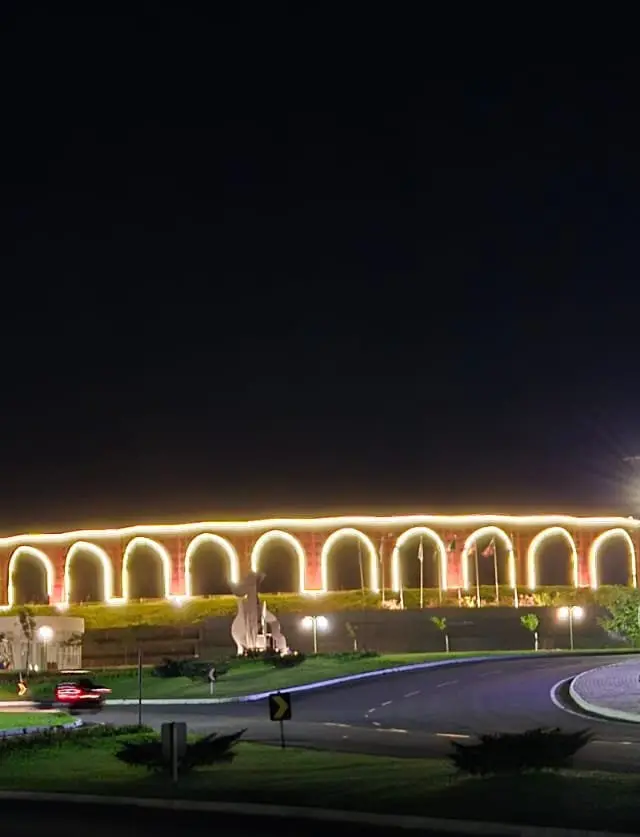 Aqueduto histórico iluminado à noite, ponto turístico destacado