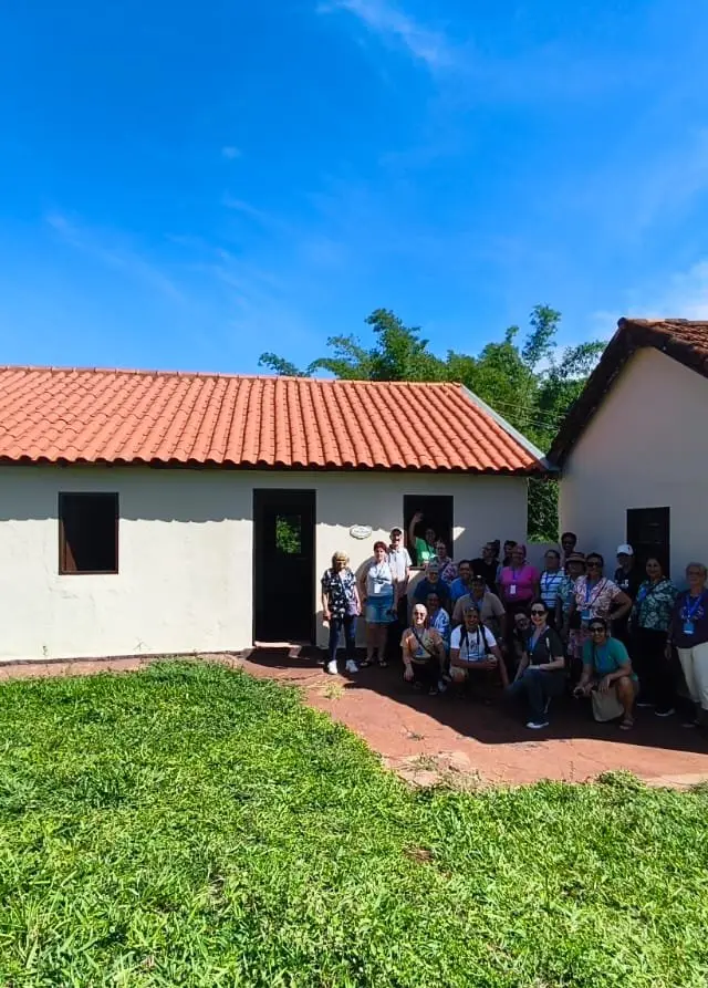 Grupo em frente a construção colonial, luz natural, momento de pausa