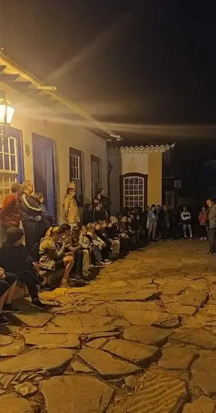 Apresentação à noite numa rua de pedra, na caravana a Minas Gerais de julho de 2024.